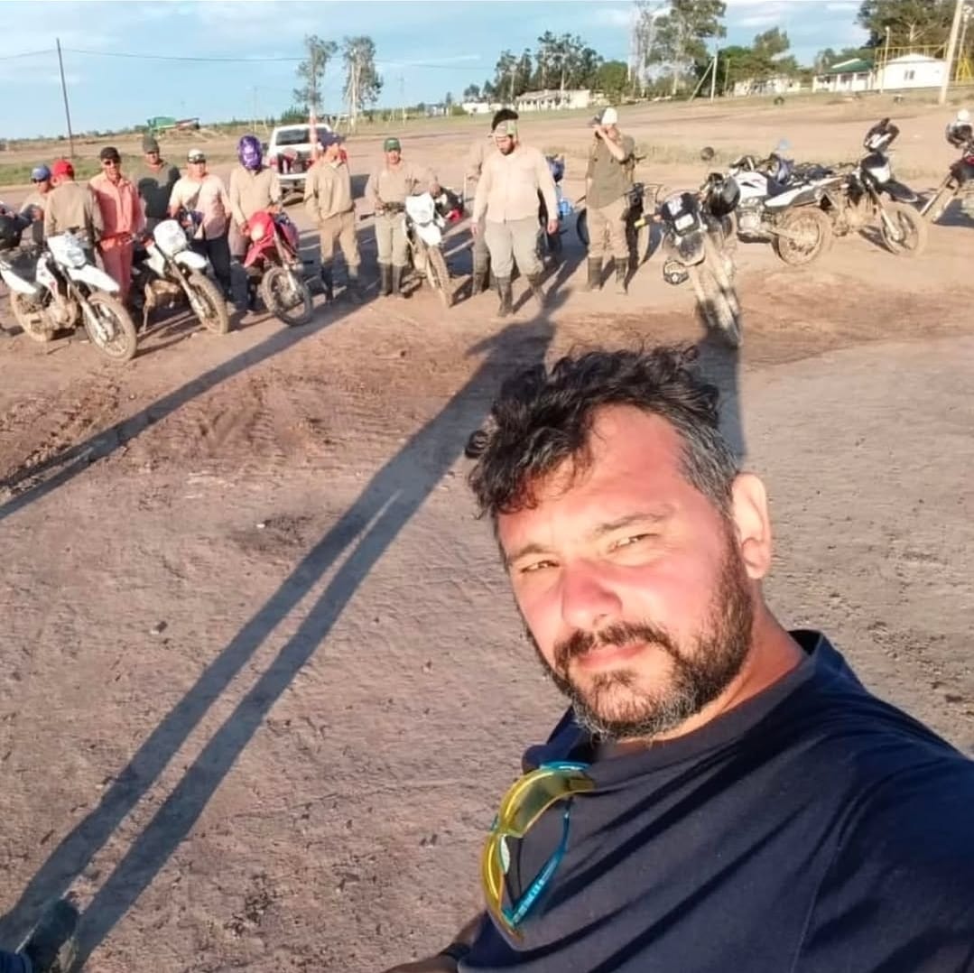 Integrante del equipo de GAF junto a un grupo de personas y motocicletas al aire libre.